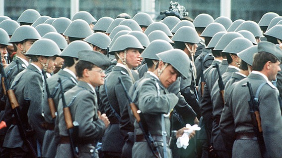 Soldaten der Nationalen Volksarmee (NVA) der DDR mit Stahlhelm auf den Köpfen und mit Maschinenpistolen marschieren am 07.10.1989 auf den Straßen in Berlin (Ost) © dpa-Zentralbild Foto: Günter Gueffroy