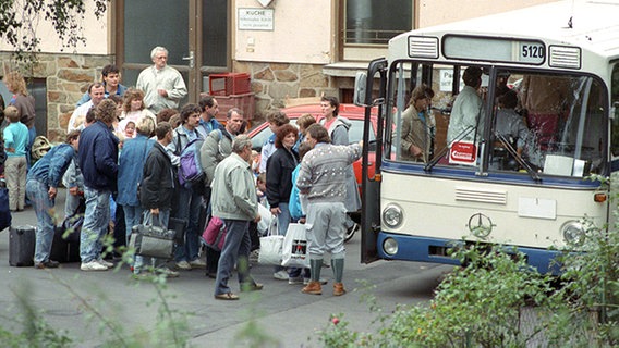 DDR-Übersiedler steigen in Busse um zu einer zentraler Aufnahmestelle gebracht zu werden. © picture-alliance/ dpa Foto: Kai-Uwe Wärner