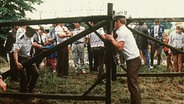 Paneuropäisches Picknick: Österreichische Grenzbeamte öffnen bei Sopron am 19 August 1989 ein Grenztor. © dpa Foto: Votava