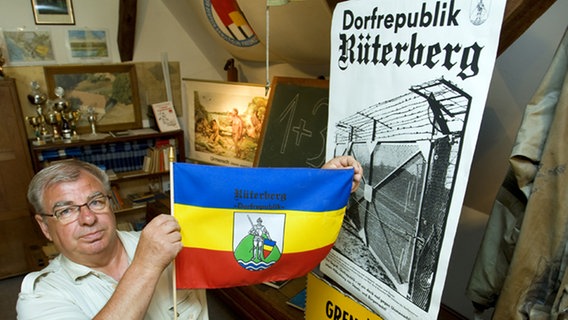 Ortschronist Meinhard Schmechel zeigt in der Heimatstube von Rüterberg die erste Fahne der Dorfrepublik © picture-alliance/ dpa Foto: Jens Büttner