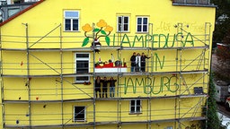 Frauen auf einem Baugerüst an einem Haus in der Hafenstraße in Hamburg.  Foto: Fernando Diosa Velez, Norbert Kotzur