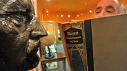 Im Band 14 von Meyers Konversationslexikon von 1914 blättert am Montag (10.11.2008) der Direktor des Naturkundemuseums Leipzig, Rudolf Schlatter. Gegenüber ist die Büste des Verlegers und Geographen Hans Meyer (1858-1929) zu sehen. © picture-alliance/ ZB Foto: Peter Endig