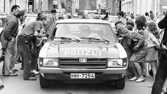 Bei der Festnahme von Fritz Honka in der Gaußstraße in Altona im Juli 1975 umringen Schaulustige das Fahrzeug der Polizei. © ullstein bild - Lutz Jaffé Foto: Lutz Jaffé