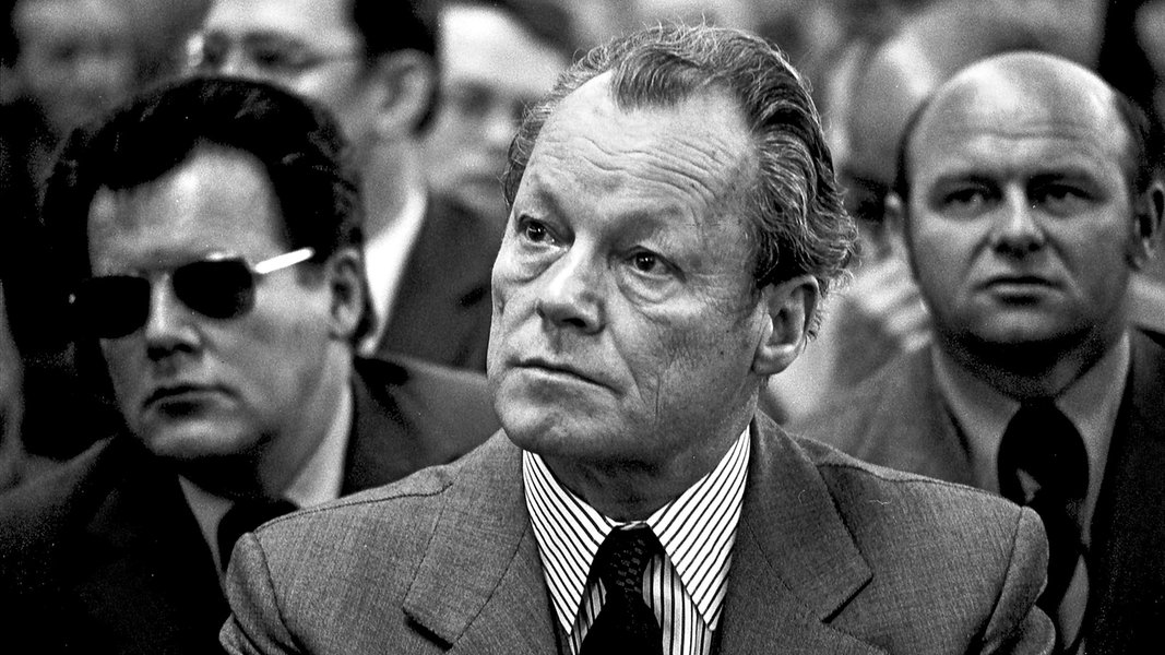 Bundeskanzler Willy Brandt (SPD) mit Günter Guillaume (links mit Brille) bei einer Veranstaltung am 08.04.1974 in Helmstedt. 