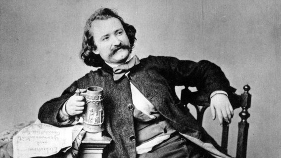 Wilhelm Busch posiert mit einem Bierhumpen. Porträt-Aufnahme von 1860. © picture-alliance / akg-images 