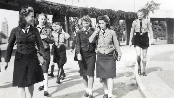Eine Gruppe Jugendlicher geht einen Weg entlang, sie tragen Uniformen der Hitlerjugend und des Bundes Deutscher Mädel. © privat 