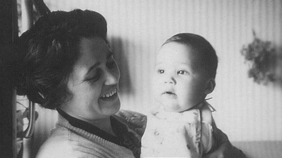Gerda Gidl lächelt und hält ihren Sohn Stephan als Baby im Arm. © privat 