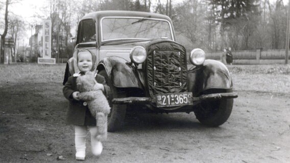 Dörte Haerder steht vor dem ersten Auto der Familie. © privat 