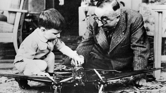 Flugzeugbauer Ernst Heinkel 1941 mit seinem Sohn und dem Modell einer "H III" beim Spielen. Flugzeugbauer Ernst Heinkel 1941 mit seinem Sohn und dem Modell einer "H III" beim Spielen. © picture-alliance / akg-images Foto: akg-images