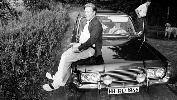 Helmut Schmidt sitzt 1974 auf einem Auto. © Friedrich-Ebert-Stiftung Foto: Darchinger
