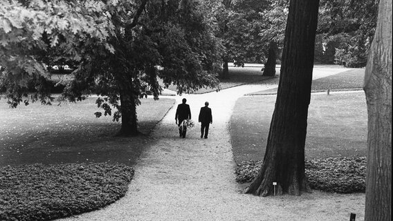 Helmut Schmidt geht 1982 mit seinem Leibwächter auf einem Weg im Garten des Kanzleramts in Bonn. © Bundesbildstelle Foto: R. Schulze-Vorberg