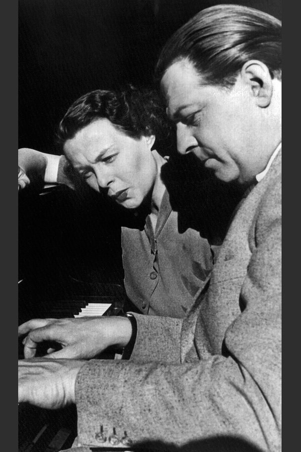 Der Schlager-Komponist Ralph Maria Siegel übt 1954 mit der pfeifenden Ilse Werner am Klavier einen Schlager ein. © picture-alliance / dpa 