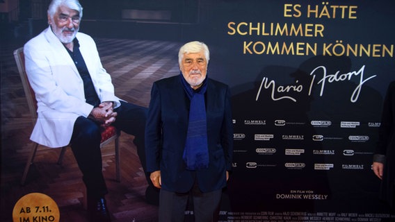 Mario Adorf posiert in der Essener Lichtburg bei der Kino-Premiere seines Dokumentarfilms "Es hätte schlimmer kommen können" vor einem Filmplakat. © Picture-Alliance / Sven Simon 