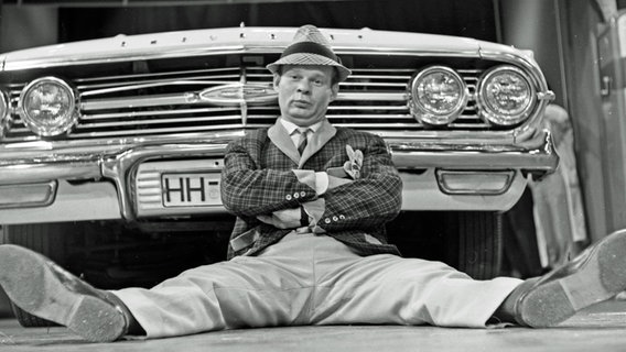 Der deutsche Schauspieler Ralf Wolter sitzt vor einem Chevrolet-Cabrio (1960er-Jahre). © picture alliance / United Archives/Pilz Foto: Siegfried Pilz