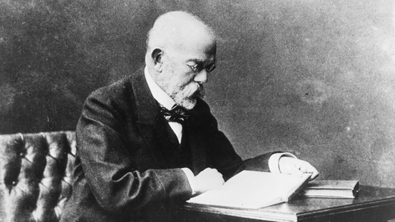 Der Bakteriologe Robert Koch liest in einem Buch. (Porträtaufnahme um 1900) © picture-alliance / akg-images Foto: akg-images