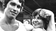 Die US-Schauspielerin Sally Field und der österrreichische Bodybuilder Arnold Schwarzenegger am 20.04.1976 während der Dreharbeiten zu dem Film "Stay Hungry". © picture-alliance/ dpa 
