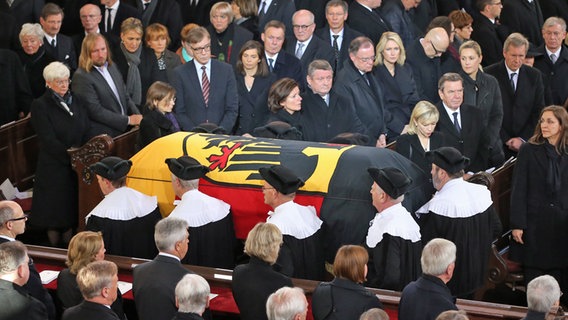 Der mit einer Flagge bedeckte Sarg des ehemaligen Bundeskanzlers Helmut Schmidt wird nach dem Staatsakt am 23. November 2015 aus der St. Michaeliskirche in Hamburg getragen. © dpa Foto: Christian Charisius