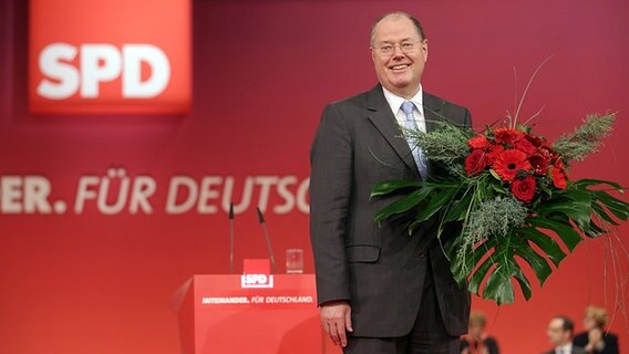 Peer Steinbrück hält auf dem Bundesparteitag der SPD in Hannover einen Blumenstrauß in der Hand. © dpa Foto: Michael Kappeler