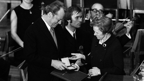 Aase Lionaes, damalige Vorsitzende des Nobelpreis-Komitee, überreicht Bundeskanzler Willy Brandt am 10. Dezember 1971 in Oslo den Friedensnobelpreis. © imago Foto: Sven Simon