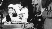 Die Ansagerin Irene Koss sitzt 1952 an einem Schreibtisch im Fernsehstudio des NWDR. © NDR 