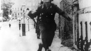 Der 19-jährige Conrad Schumann flüchtet am 15. August 1961 mit einem Sprung über eine Stacheldrahtabsperrung vom sowjetischen Sektor in den Westteil Berlins. © dpa Foto: UPI