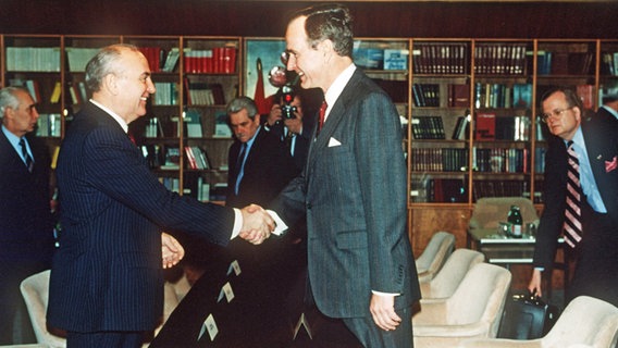 US-Präsident George Bush und der sowjetische Staats- und Parteichef Michail Gorbatschow reichen sich im Dezember 1989 auf dem Kreuzfahrtschiff TS "Maxim Gorkiy" die Hand. © dpa - Bildarchiv Foto: AFP