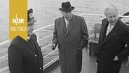 Großenbrode: Indienststellung des Fährschiffs "Theodor Heuß". Novermber 1957. Bundespräsident Theodor Heuss, Verkehrsminister Hans-Christoph Seebohm und der Kapitän posieren für Reporter an Deck. © NDR Archiv Screenshot 