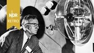 Dr. Allen V. Astin (um 1957), Direktor des National Bureau of Standards und Mitglied des Nationalen Komitees der USA für das Internationale Geophysikalische Jahr studiert ein Schnittmodell des Erdsatelliten, der von den Vereinigten Staaten gestartet werden soll. © IMAGO / UIG 
