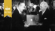 Der Lübecker Bürgermeister Passarge überreicht Thomas Mann die Ehrenbürgschaft. © NDR Archiv Screenshpt 