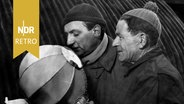 Eine scharfe Brise wehte auf Helgoland. Hermann Rockmann und Robert Grasnick umgeben das Mikrofon mit einem Windschutz, 1947. © NDR Presse und Information Foto: Hans Müller