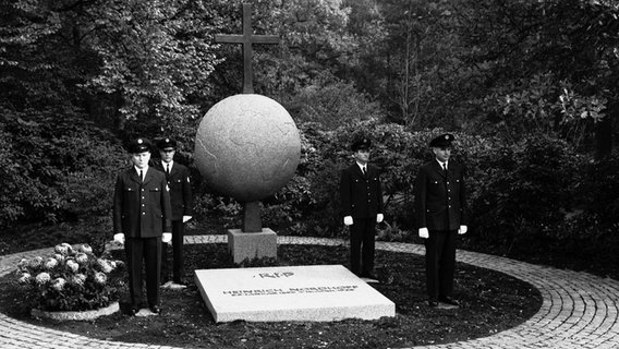 Vier uniformierte Männer stehen 1968 am Grab des VW-Vorsitzenden Heinrich Nordhoff auf dem Waldfriedhof in Wolfsburg. © Volkswagen AG 
