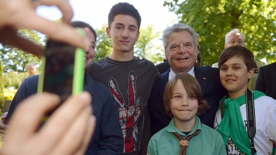 Bundespräsident Joachim Gauck (h.) lässt sich mit Besuchern im Arm fotgrafieren © picture alliance / dpa Foto: Marcus Brandt