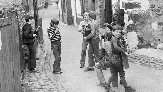 Jungen stehen mit einer Rassel oder Ratsche auf der Straße. © picture-alliance / United Archives 