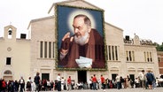 Die Kirche von San Giovanni Rotondo, Wirkungsstätte von Padre Pio, ist 2002 mit einem überdimensionalen Porträt des Padre geschmückt. © picture-alliance / dpa Foto: Rolf Haid
