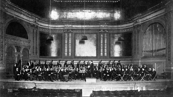 Konzertprobe des Philharmonischen Orchesters New York im Jahr 1902 mit Walter Damrosch als Dirigent. © picture alliance / akg-images | akg-images 