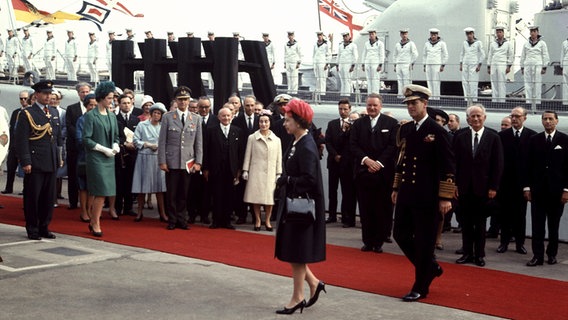 Die britische Königin Elizabeth II. (M) begibt sich am 28. Mai 1965 im Hafen von Hamburg zur königlichen Yacht "Britannia". © picture alliance / dpa Foto: Horst Ossinger