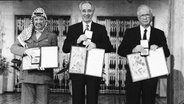 PLO-Führer Jassir Arafat (l), der israelische Premierminister Yitzhak Rabin (m) und der israelische Außenminister Shimon Peres 1994, nachdem sie den Friedensnobelpreis im Rathaus von Oslo erhalten haben. © picture alliance / AP Photo 