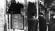 Passanten vor einer zerstörten Fensterfront eines jüdischen Geschäfts in Berlin nach der Reichspogromnacht im November 1938. © picture alliance/KEYSTONE | STR 
