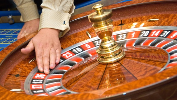 Hand an einem Roulette-Rad © Fotolia.com Foto: Denys Kurbatov