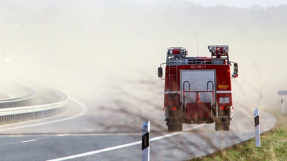 Ein Feuerwehrauto fährt in einen Sandsturm © picture alliance/Bernd Wüstneck/dpa-Zentralbild/dpa Foto: Bernd Wüstneck