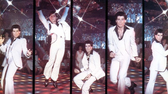 John Travolta tanzend in Szenenbildern des Films "Saturday Night Fever" in einer Disco. © picture alliance/Mary Evans Picture Library 
