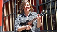 Beatles-Expertin Stefanie Hempel spielt Ukulele vor dem Indra in St. Pauli. © NDR Foto: Heiko Block