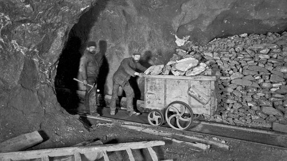 Bergarbeiter mit einem Förderwagen beim Erztransport in einem Stollen um 1910. © Oberharzer Bergwerksmuseum 