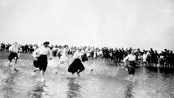 Strandleben im Nordseebad Büsum: Wettlauf von Mädchen im Wattenmeer. Foto, 1911 (Otto Haeckel). © picture alliance / akg-images 