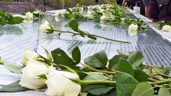 Rosen liegen auf den Tafeln mit den Namen Deportierter am Gedenkort Hannoverscher Bahnhof in Hamburg. © NDR Foto: Irene Altenmüller