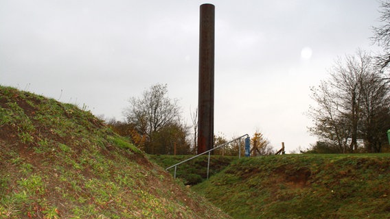 Neben den "Überresten" eines ehemaligen Panzerabwehrgrabens steht eine Stele, "Das Mal". © NDR Foto: Bettina Meier