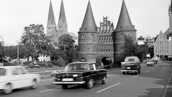 Vor dem Holstentor in Lübeck fahren Pkw entlang, aufgenommen 1965. © picture alliance/United Archives | Siegfried Pilz Foto: Siegfried Pilz