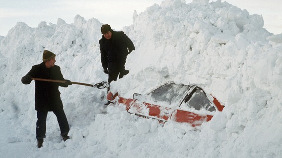 Zwei Männer graben mit einer Schaufel ein Auto aus den Schneemassen. Aufnahme vom Januar 1979. © picture-alliance / dpa Foto: Spring