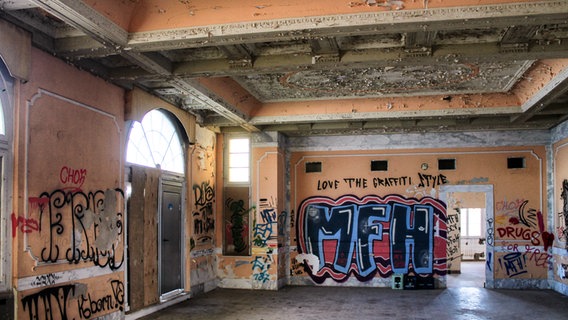 Die Wände des früheren Ballsaals in der Villa Baltic in Kühlungsborn sind mit Graffiti besprüht, vom Stuck an der Decke bröckelt die Farbe. © NDR Foto: Daniel Sprenger