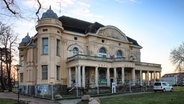 Die Vorderfassade der Villa Baltic in Kühlungsborn, die von einem Bauzaun umgeben ist. © NDR Foto: Daniel Sprenger
